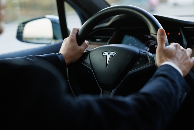 Someone's hands on the steering wheel of a Tesla Model Y